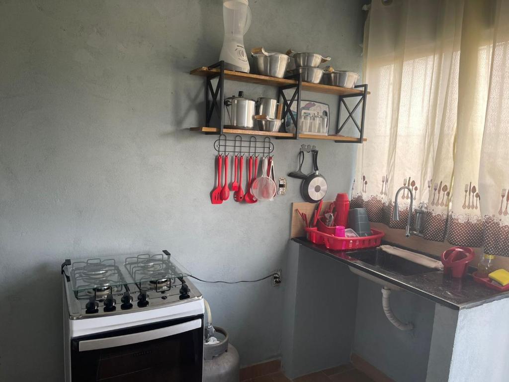 a kitchen with a stove and a counter with utensils at Apê Bianck's in Ilha Comprida