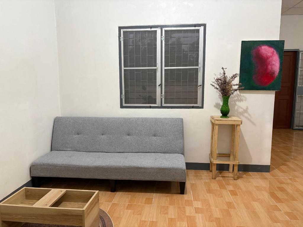a living room with a couch and a window at Mama's Tree Homey Studio in Ban Klaeng Lang