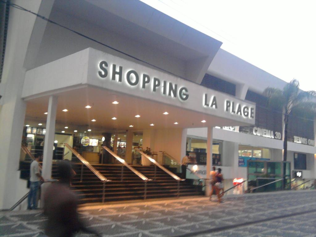 un centro comercial con gente caminando delante de él en Apartamento Pitangueiras - Guaruja, en Guarujá