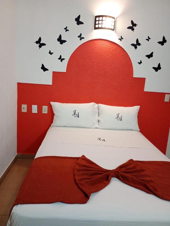 a bed with a red headboard with bats on it at J Alejandro - Centro Histórico Guadalajara in Guadalajara