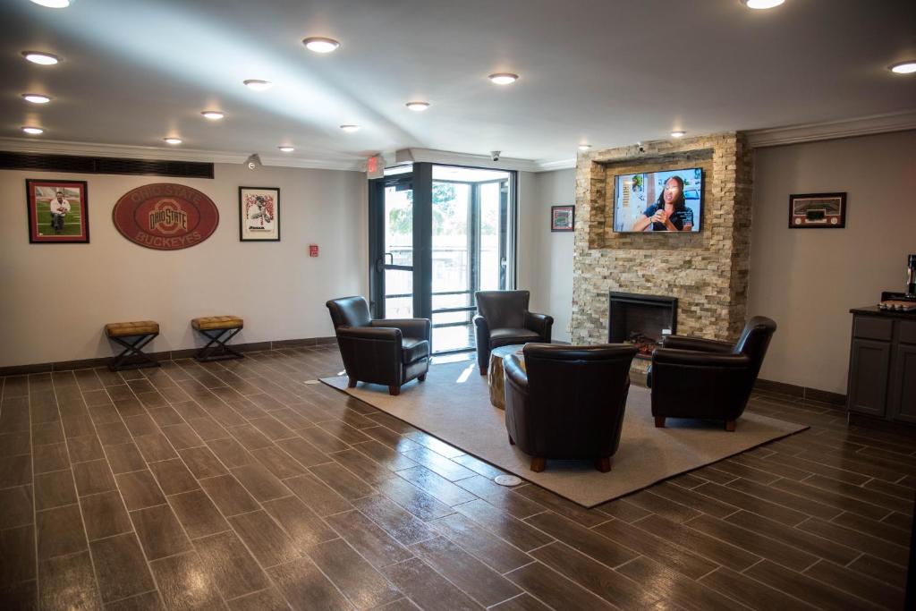 a waiting room with chairs and a fireplace at Baymont Inn and Suites by Wyndham Columbus / Near OSU in Columbus