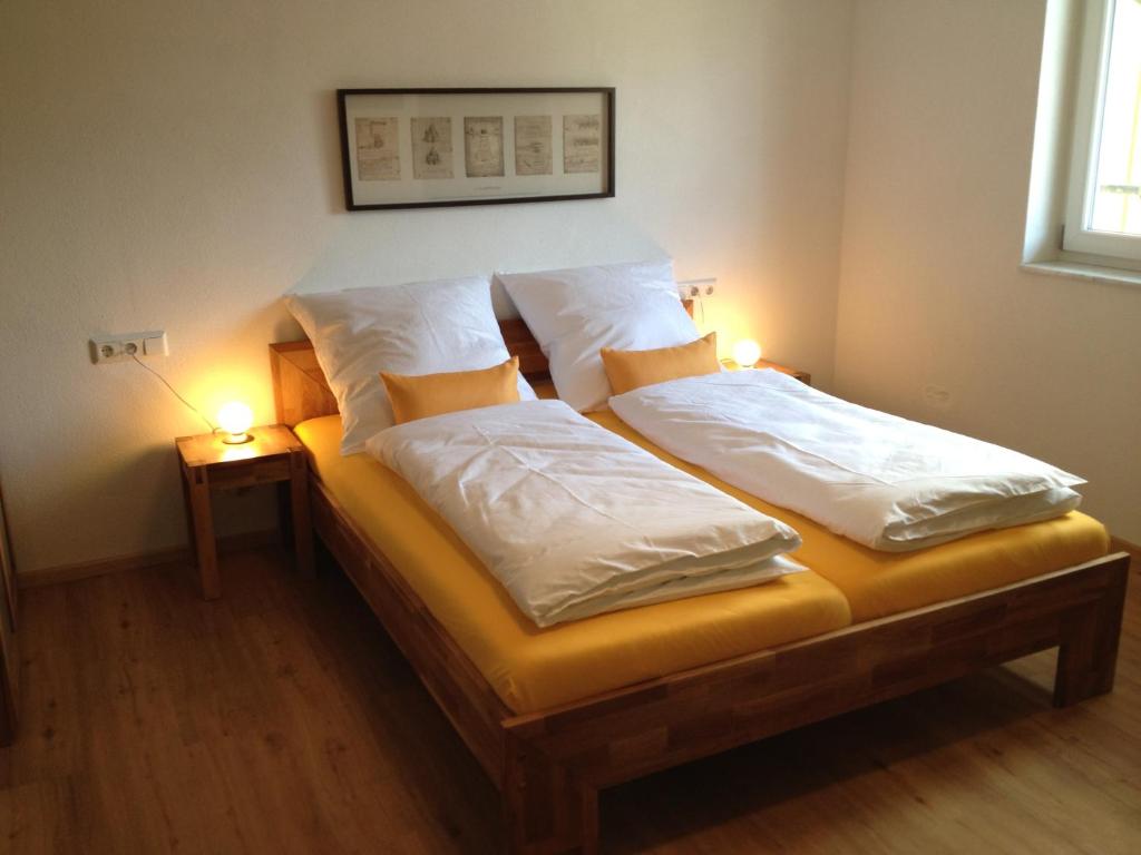 two twin beds in a room with two lamps at Pension Neulen in Rust