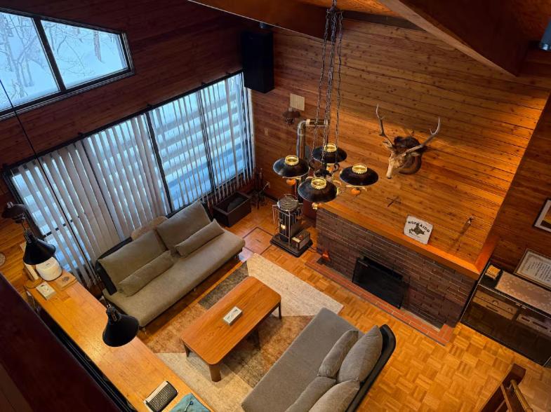 a living room with a couch and a fireplace at Yama Chalet in Rankoshi