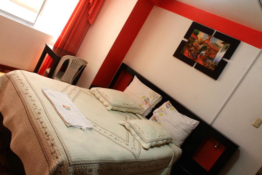 sypialnia z łóżkiem z poduszkami w obiekcie Amaru Hotel Huaraz w mieście Huaraz