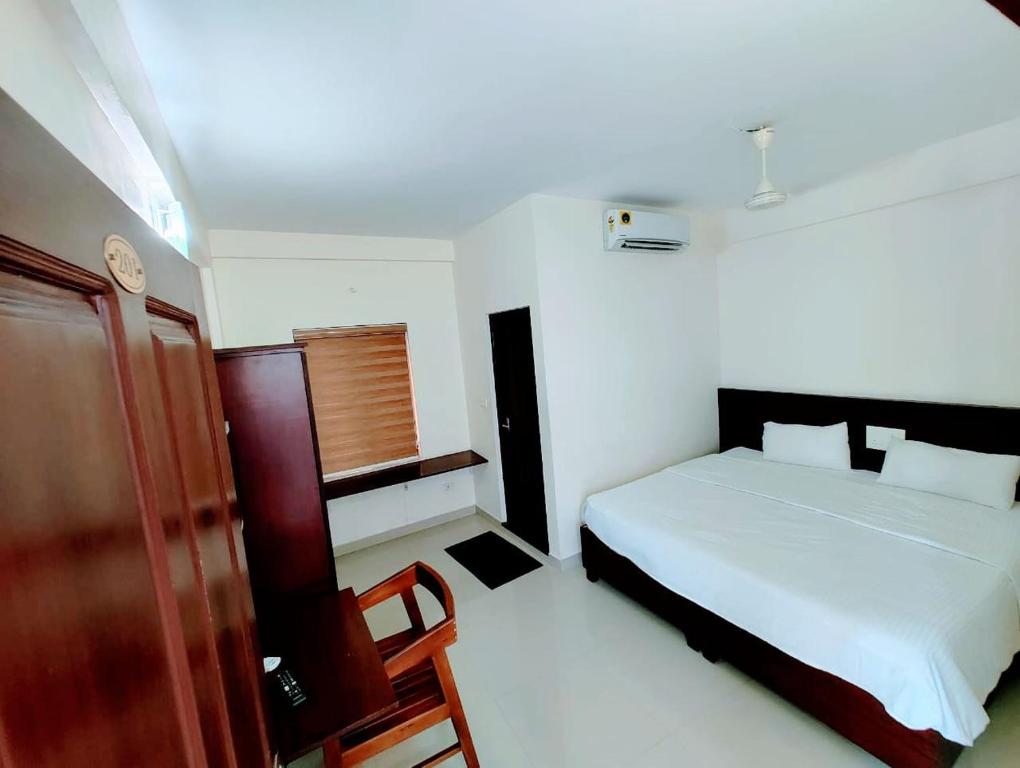 a small bedroom with a bed and a window at Masterkey stay in Kakkanad