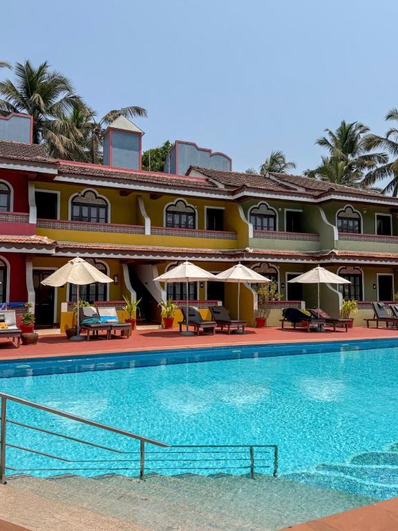 a hotel with a swimming pool in front of it at Skylark Resort in Colva