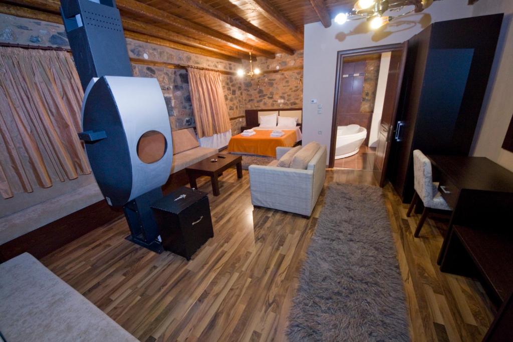 a living room with a tv and a bedroom at Xenonas Piperitsa in Palaios Agios Athanasios