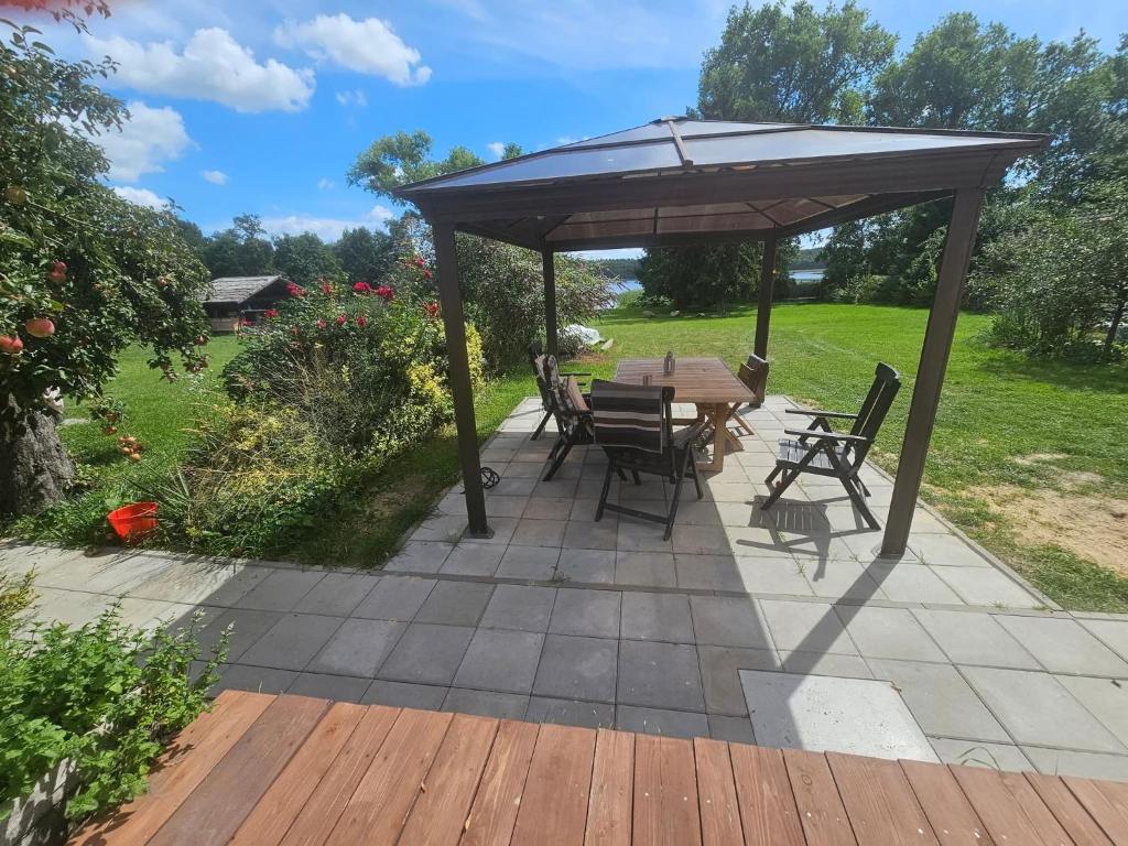 a table and chairs under an umbrella on a patio at Dom Nad Jeziorem in Wolin