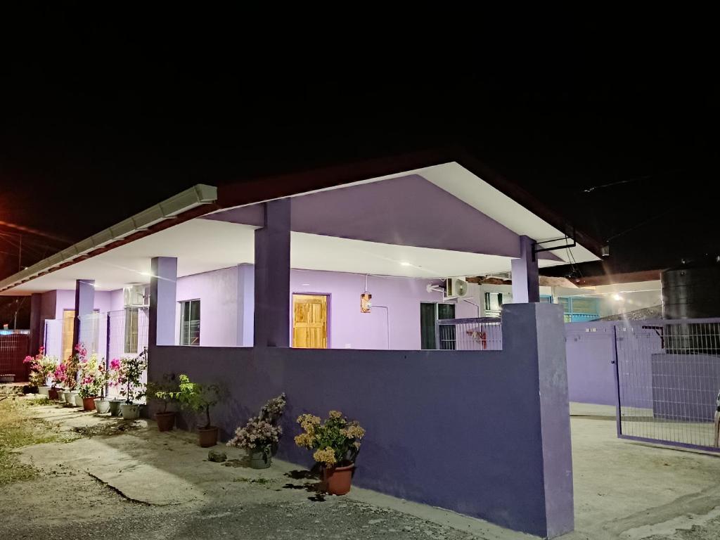 a small house with purple walls and potted plants at Rumah Impian Bapa in Semporna