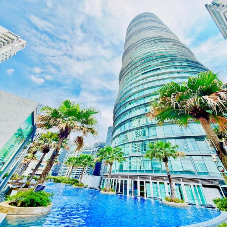 a tall building with palm trees in front of it at Vortex by klcc view in Kuala Lumpur