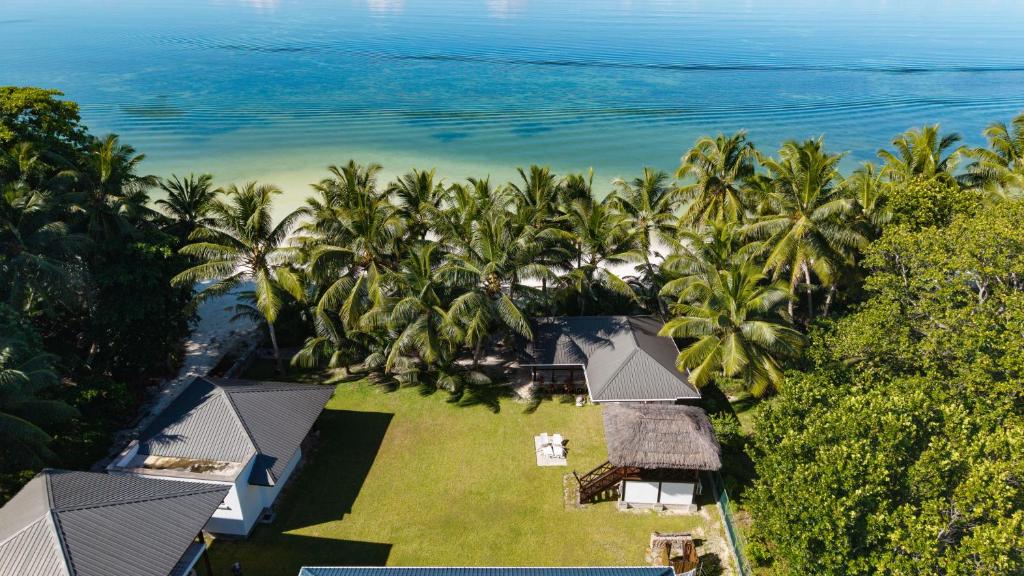 an aerial view of a resort with palm trees and the ocean at Reve Island Lodge in Grand Anse