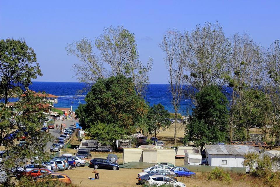a parking lot with cars parked next to the ocean at Tangra Guest House in Arapya