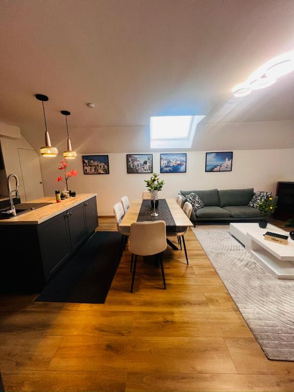 a kitchen and living room with a table and a couch at Victoria Prestige Parking Gratuit in Boussu