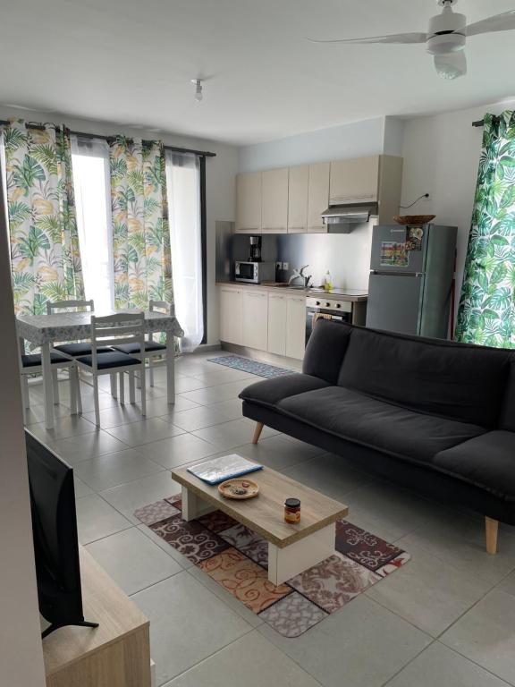 a living room with a black couch and a table at Résidence Le Carillon in Saint-André