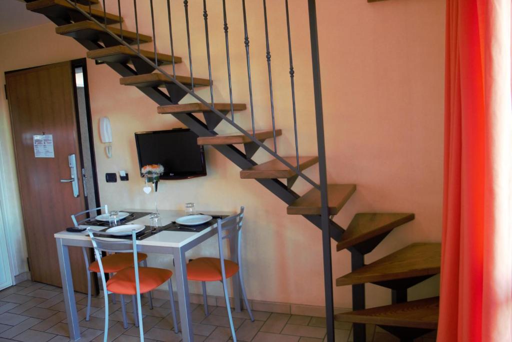 a kitchen with a table and a spiral staircase at Borgo Castel Savelli in Grottaferrata