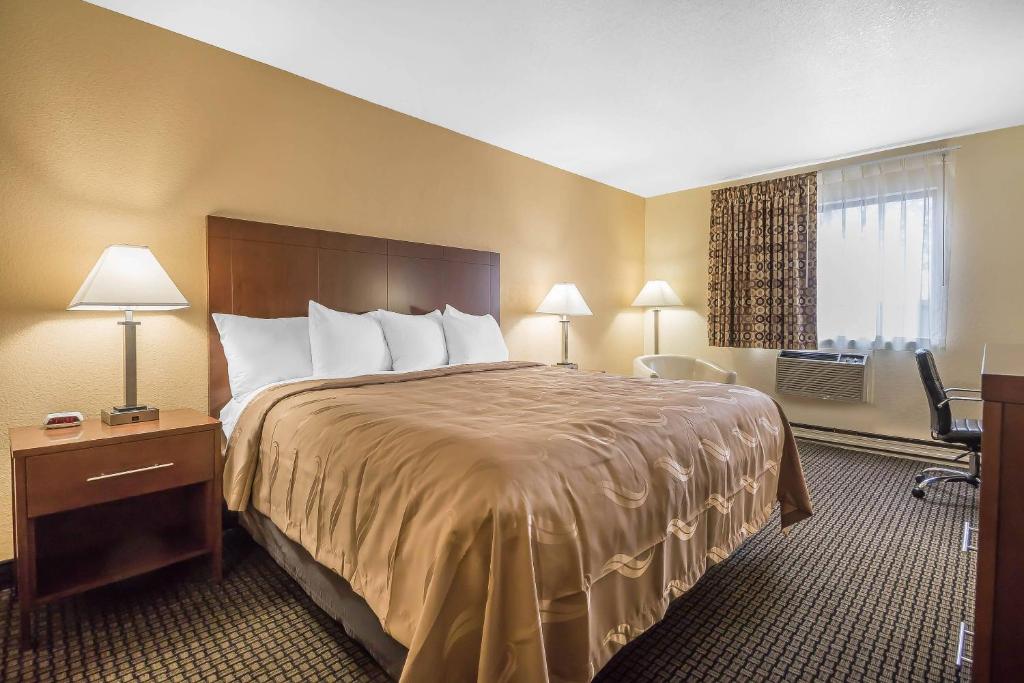 a hotel room with a large bed and a window at Quality Inn Janesville North in Janesville