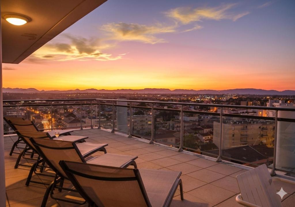 a balcony with chairs and a view of a city at Sunset Horizon Canet - Vue Panoramique Mer Montagne in Canet-en-Roussillon