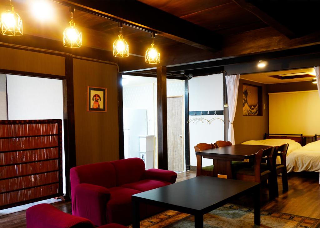 a living room with a couch and a table and a bed at マホロバハウス ペットも泊まれる1棟貸 in Tadotsu