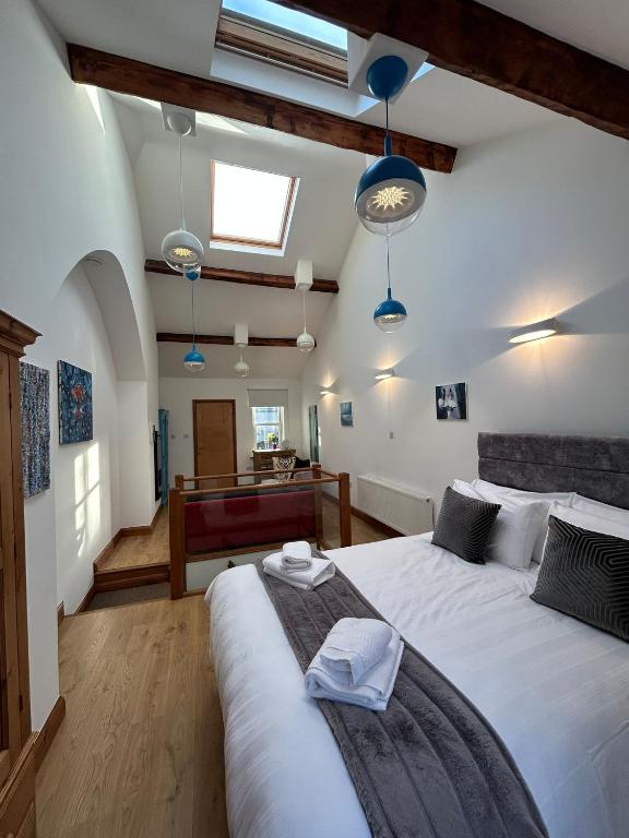 a bedroom with a large white bed and blue lights at Orebank Cottage in Millom