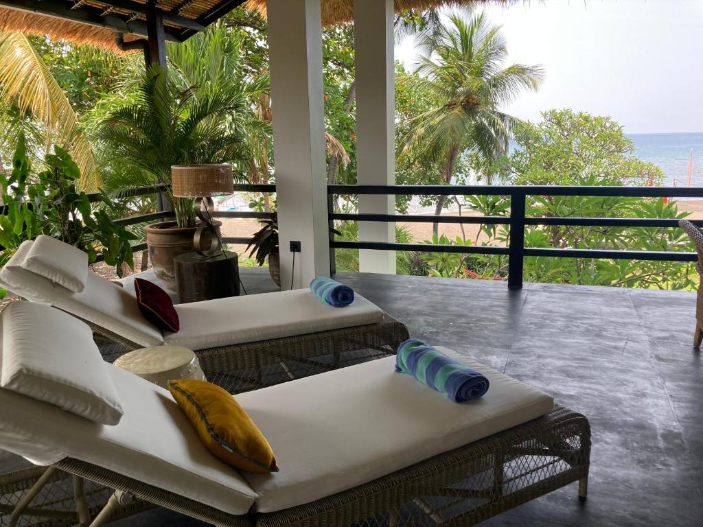 a living room with a couch and a view of the ocean at Villa Rawarawa Private Beachfront in Central of Lovina by GEMA MANAGEMENT BALI in Lovina