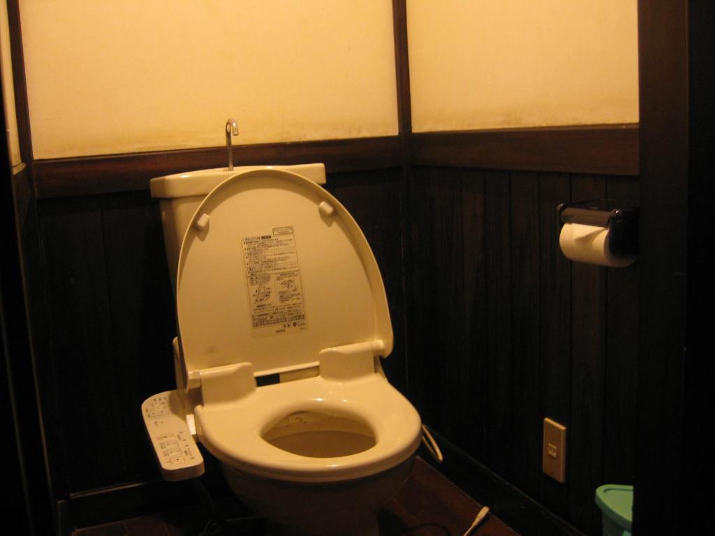 La salle de bains est pourvue de toilettes avec un couvercle. dans l'établissement Yumoto Choza, à Takayama 55 autres photos