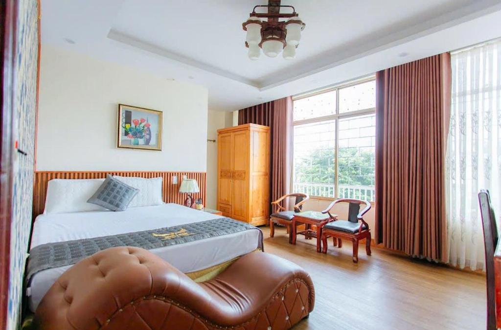a hotel room with a bed and a chair at Hotel Nhu Loan in Bạch Ðoài