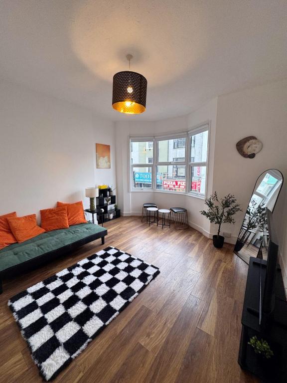 a living room with a couch and a checkered rug at Literally Central Brighton Sleeps 8 in Brighton & Hove