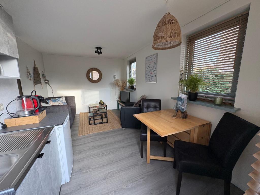 a kitchen and living room with a table and a dining room at Waves in De Koog