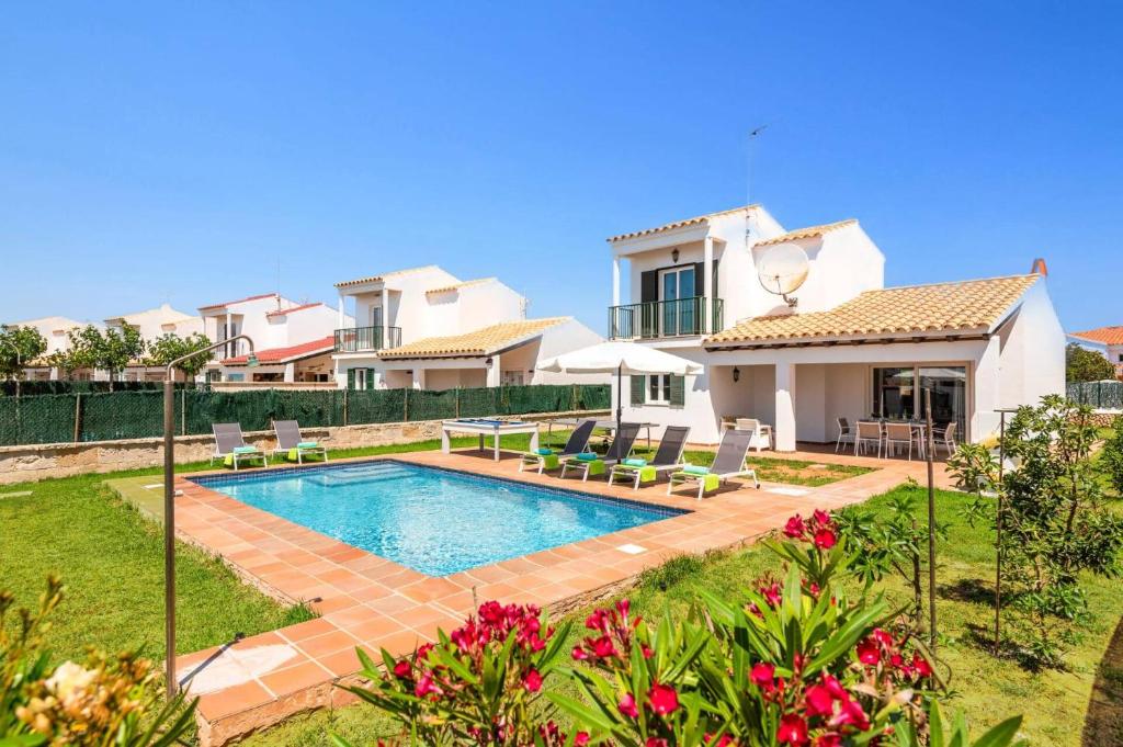 a villa with a swimming pool in front of a house at Villa Vientosol by Villa Plus in Cala en Forcat