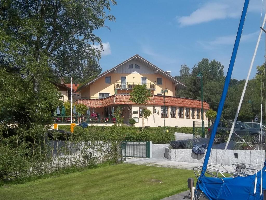 a house in the background with a yard at Hotel Mutz in Inning am Ammersee