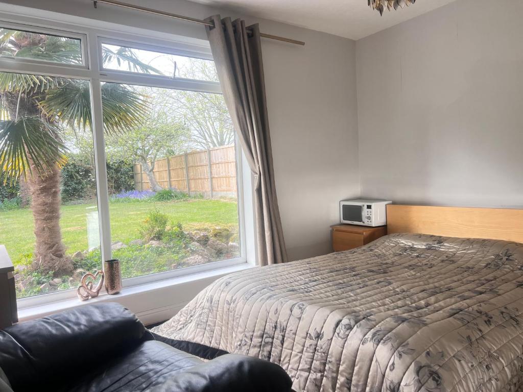 a bedroom with a bed and a large window at Zen suite in Oadby
