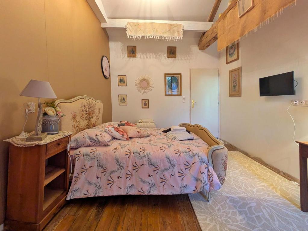 a bedroom with a bed and a table with a lamp at chambre chez hote familiale 2, 4, 5,6 in Mareuil-sur-Lay