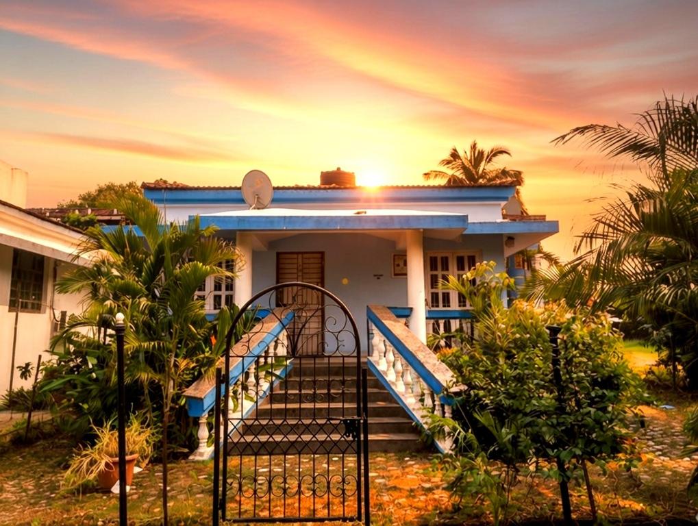 a house with a gate with a sunset in the background at Kinara 2 bhk Villa in Varca