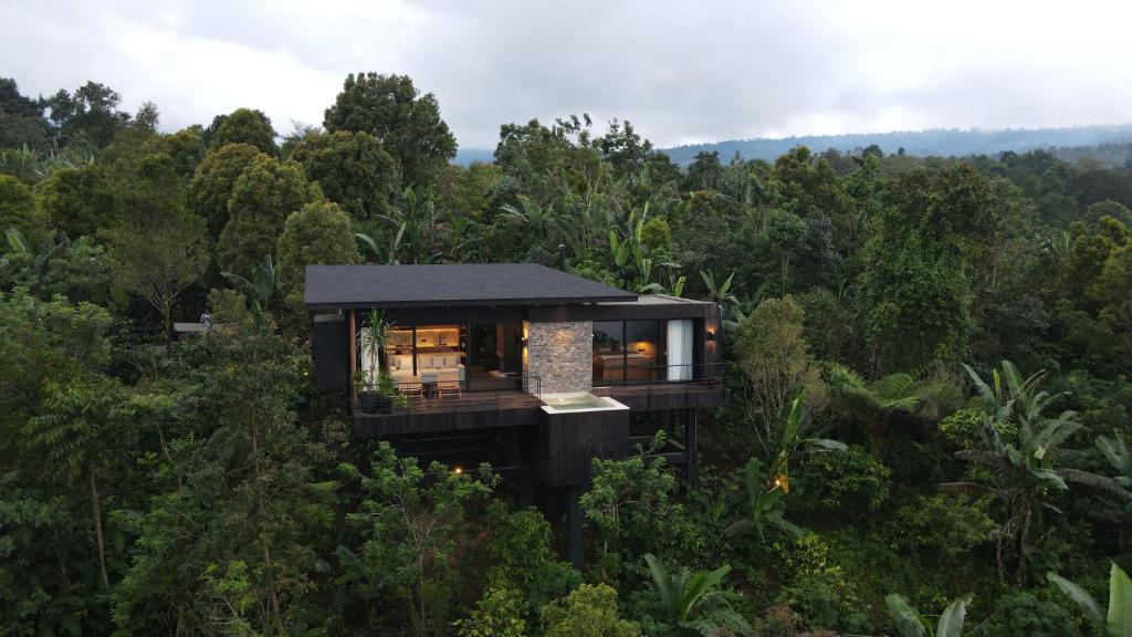 a black house in the middle of the forest at The Bataran Cabin in Gitgit