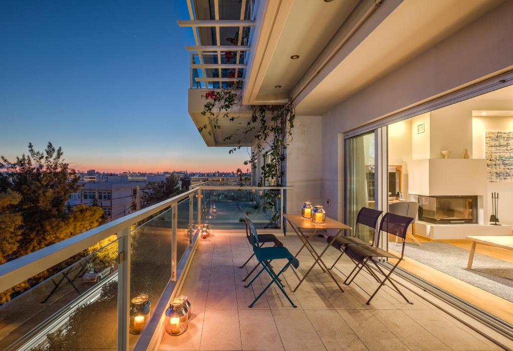een balkon met een tafel en stoelen en uitzicht bij Scale Suites in Athene