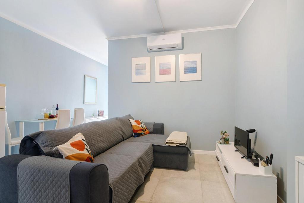 a living room with a couch and a tv at Apartamento Sun7set in Quarteira