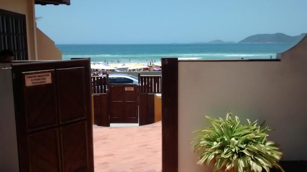 a view of the beach from a hotel room with a gate at Apart Hotel Praia do Pero in Cabo Frio