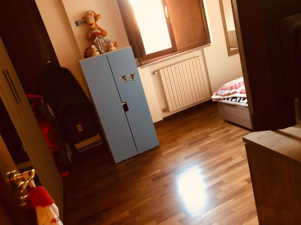 a room with a refrigerator and a wooden floor at Casa Alma in Cogliate