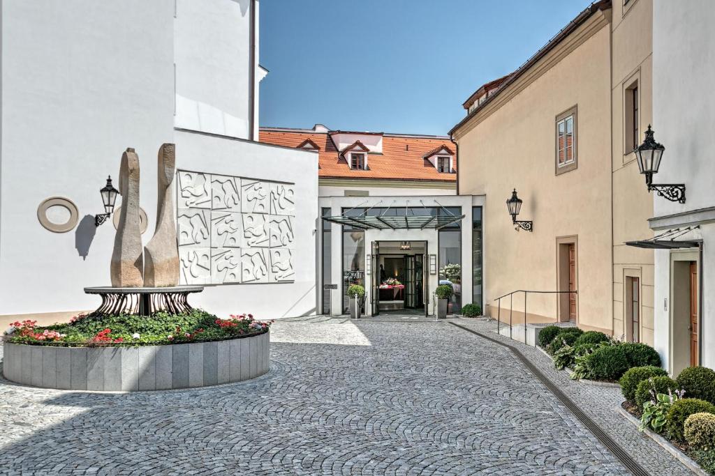 a courtyard with a statue in front of a building at Augustine Hotel, Prague in Prague