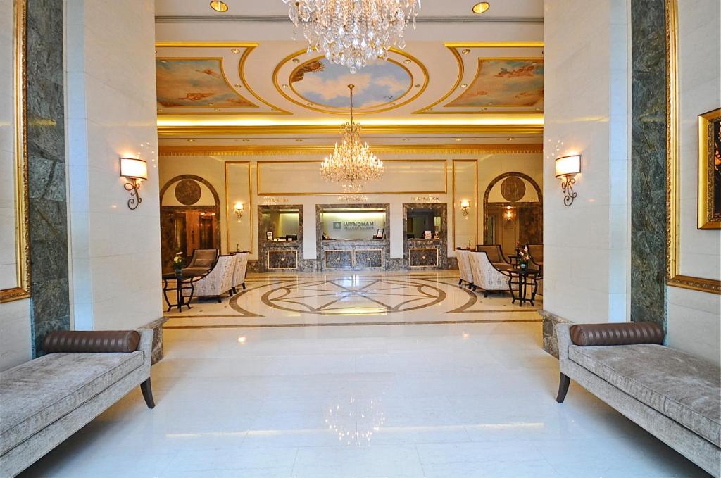 a lobby with two benches and a chandelier at Vacation Rental Suites at Royal Garden Waikiki in Honolulu