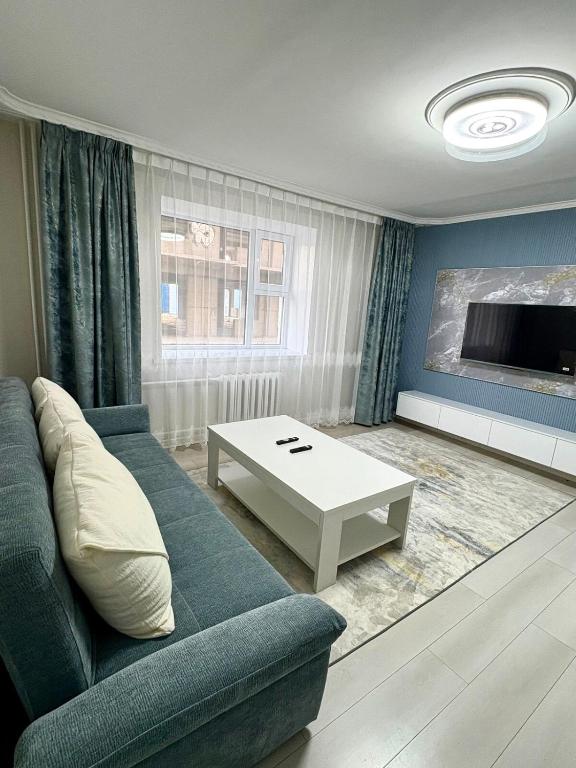 a living room with a blue couch and a table at Gegee's House in Ulaanbaatar