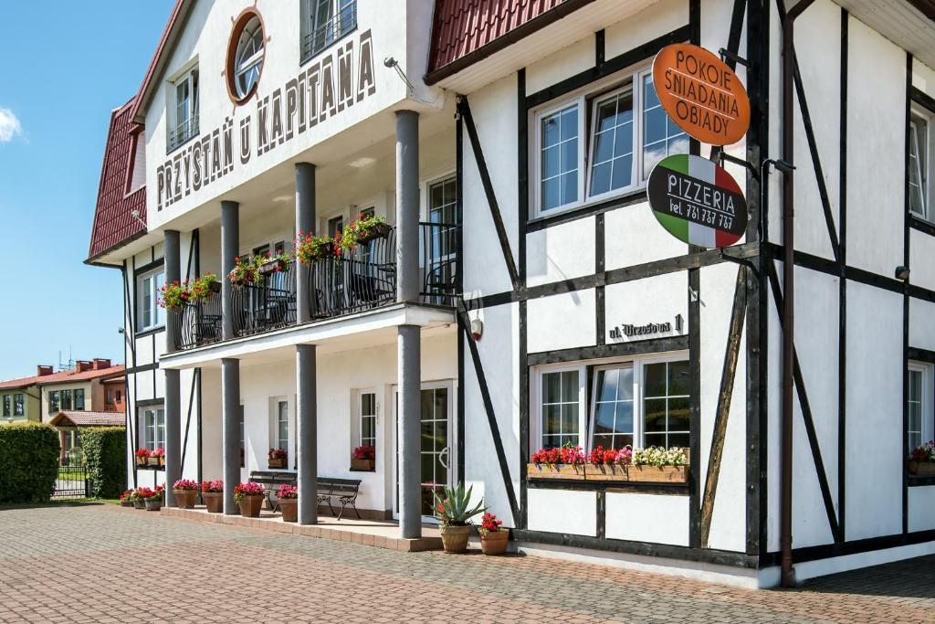 a building with flowers on the balconies and a street at Przystań u Kapitana in Ustka
