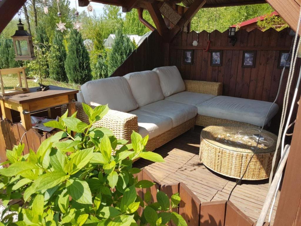 a patio with a couch and a table at Familienurlaub am See - Haus nr 1 - Rokitki in Rokitki