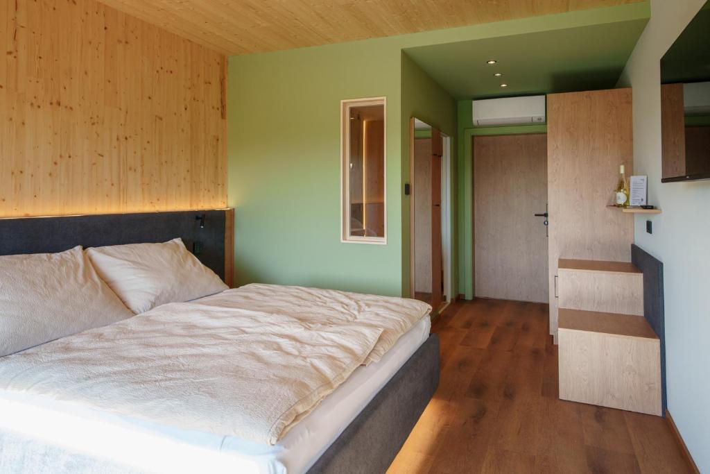 a bedroom with a bed and a green wall at Schlafgut am Johanneshof in Tattendorf