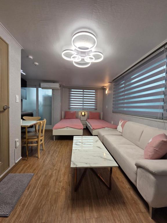 a living room with a couch and a table at Forêt Guest House Gangnam in Seoul