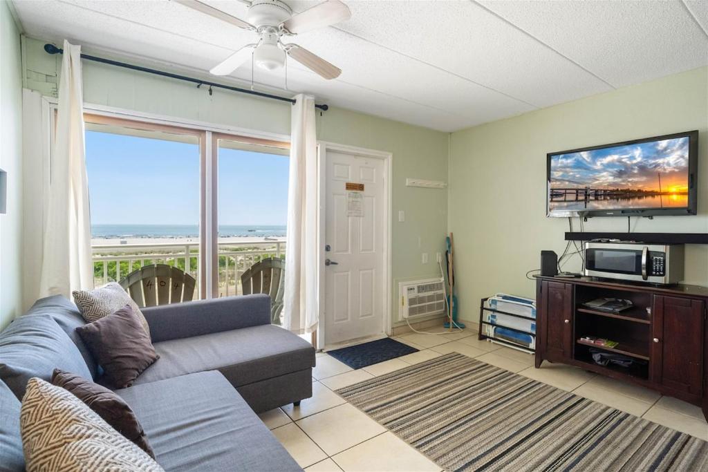 a living room with a couch and a flat screen tv at Oceanfront Condo w Heated Pool & Reserved Parking in Wildwood Crest