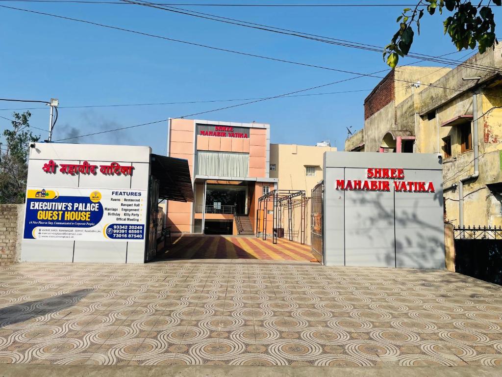 two buildings with signs on them on a street at Executives palace in Rāmgarh