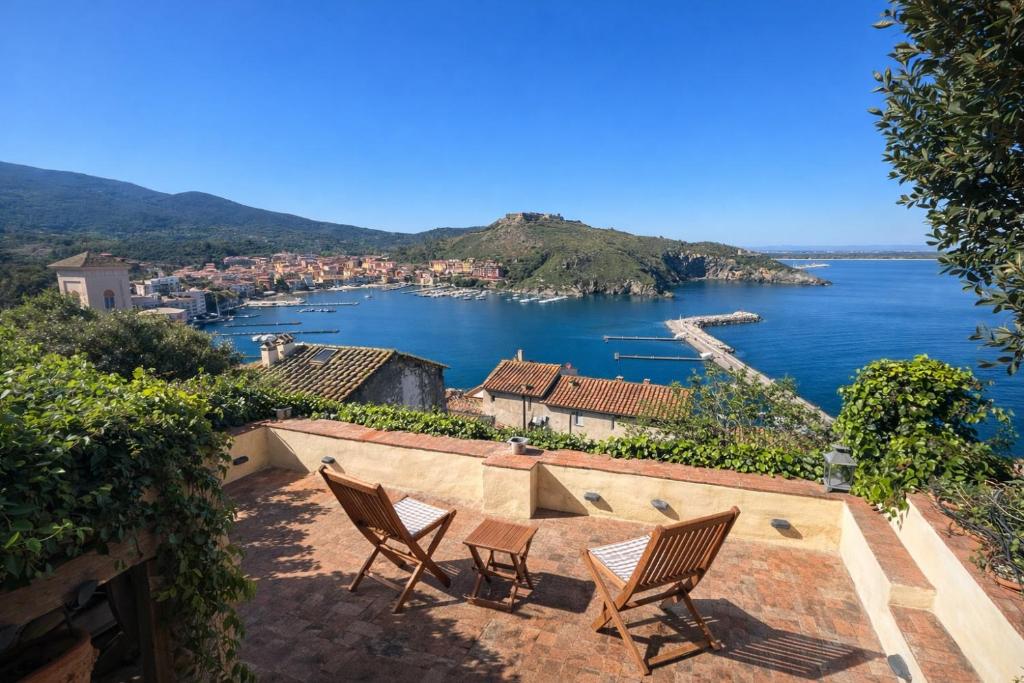 a patio with two chairs and a view of the water at Exclusive Villa - Relax - A-C - Stunning View in Porto Ercole
