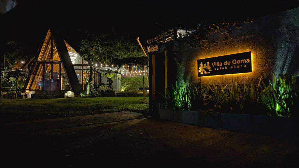 a sign for an all white game center at night at Villa de Gema in Selabintana