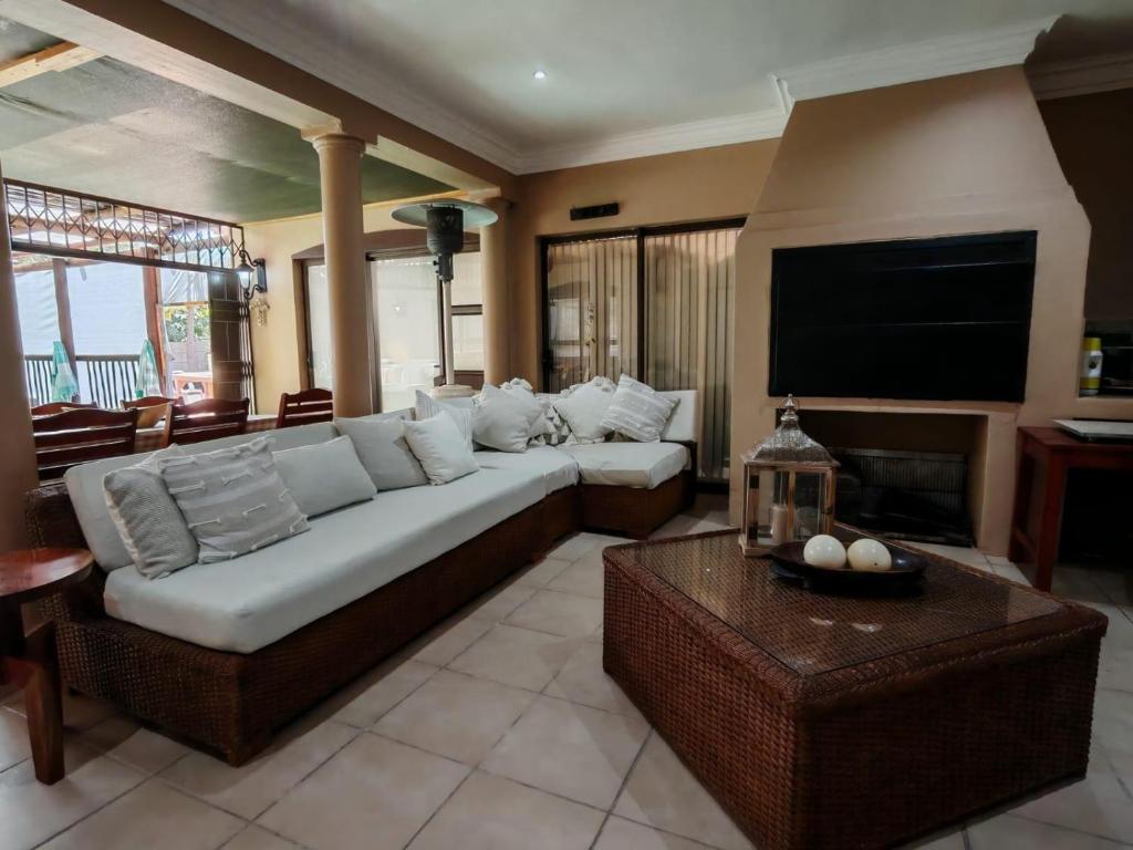 a living room with a couch and a flat screen tv at Merensee in Langebaan